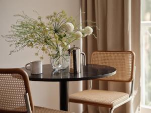 a black table with a vase of flowers on it at Bob W Munich Schwabing in Munich +53 photos