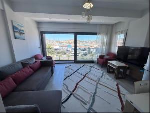 a living room with a couch and a large window at Vista Marina Çeşme in Çeşme