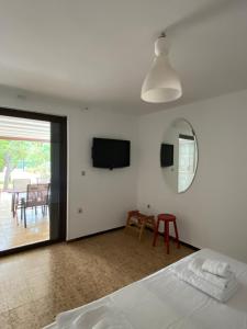 アテネにあるGlyfada Charm, Little home with private parkingのベッドルーム1室(ベッド1台、鏡、テーブル付)