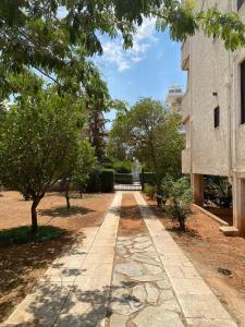 アテネにあるGlyfada Charm, Little home with private parkingの木々や建物のある公園の歩道 +32枚の写真