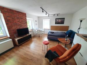 a living room with a couch and a brick wall at Apartament Chełmsko Śląskie in Chełmsko Śląskie