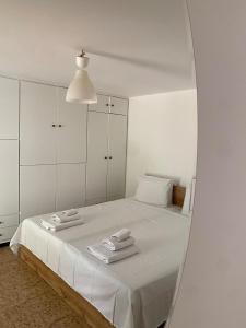 アテネにあるGlyfada Charm, Little home with private parkingの白いベッドルーム(鏡付きベッド1台付)