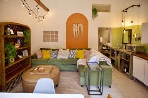 a living room with a green couch and a kitchen at Casa Verdejo - Zona Romantica in Puerto Vallarta