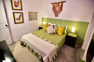 a bedroom with a green bed with stuffed animals on it at Casa Verdejo - Zona Romantica in Puerto Vallarta