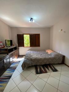 a bedroom with a bed and a television in it at Casa em Guaramiranga, ao meio da Natureza! in Guaramiranga