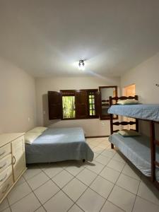 a bedroom with two bunk beds and a window at Casa em Guaramiranga, ao meio da Natureza! in Guaramiranga