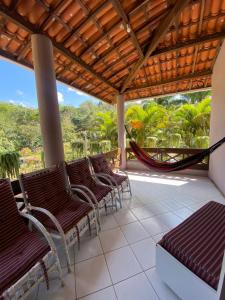 a porch with chairs and a hammock on it at Casa em Guaramiranga, ao meio da Natureza! in Guaramiranga