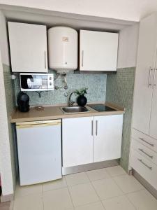 a kitchen with white cabinets and a sink at Sea view Cascais in Cascais +32 photos