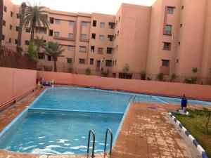 a swimming pool in front of a building at Marrakech Sakan Annakhil im6 n31 in Marrakesh