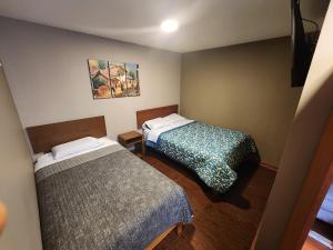 a room with two beds in a room at Hospedaje Casa Huayra in Cusco