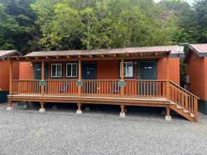 a small orange house with a large deck at Rogue River Landing Resort in Gold Beach