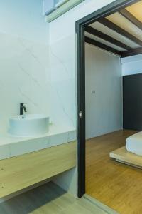 パタヤ・ノースにあるSaga Pool Houseの白い洗面台と鏡のあるバスルーム