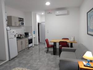 a living room with a couch and a table and a kitchen at Monoambiente Estela in San Pedro