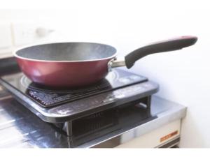 a pan on top of a stove with a spatula at Guest House Shine Bright - Vacation STAY 19292 in Fukuoka