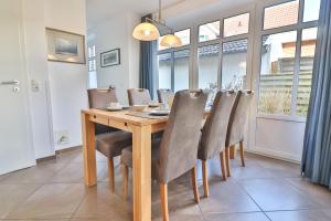 a dining room with a wooden table and chairs at Strandlust in Langeoog