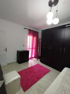 Banī Ghālibにある2 Room Apartment in CAIROのピンクのラグと黒いドアのあるリビングルーム