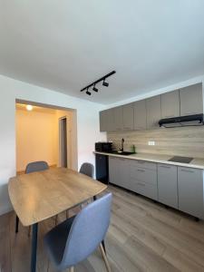a kitchen with a wooden table and chairs at Transylvania Guest House in Braşov