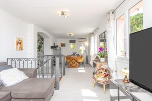a living room with a couch and a tv at Villa with Panoramic Sea View & Private Pool Roquebrune-Cap-Martin & Monaco in Roquebrune-Cap-Martin