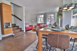 a dining room and living room with a table and chairs at Tweethus in Langeoog