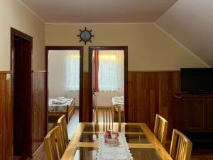a dining room with a glass table with a cake on it at Bettina Apartman in Sovata