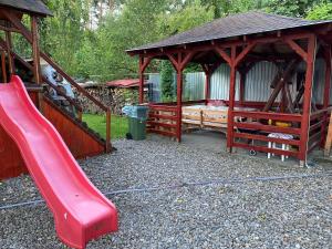 a playground with a red slide and a gazebo at Bettina Apartman in Sovata