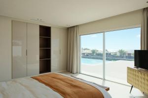 Un dormitorio con una cama grande y una ventana grande en Villa Ainé Luxury Villa, en Puerto Calero 20 fotos más