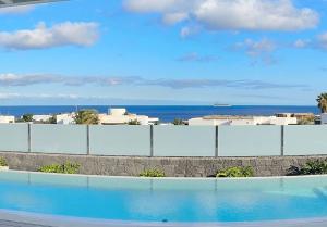 una piscina con el océano al fondo en Villa Ainé Luxury Villa, en Puerto Calero