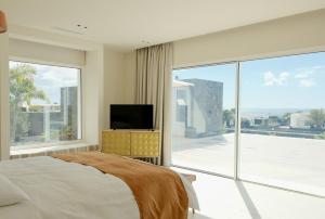 Un dormitorio con una cama y una gran ventana de cristal. en Villa Ainé Luxury Villa, en Puerto Calero