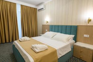 a bedroom with a large bed with towels on it at Hotel Letos Mamaia Nord in Mamaia Sat/Năvodari