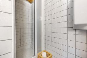 a white tiled shower with a basket in a bathroom at Intera casa Lago di Garda in Brenzone sul Garda