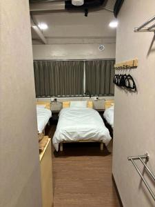 a room with three beds in it with a window at Wasabi Mita Hotel - Vacation STAY 84702v in Tokyo