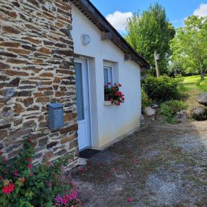 a stone house with a window and a door at Gouarec La Petite Maison in Gouarec