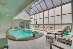 a large swimming pool in a large room with windows at Indoor Pool and Waterfront Deck Spacious Jay Home in Jay
