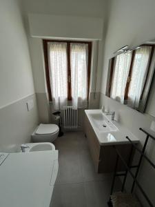 a bathroom with a sink and a toilet and a mirror at Appartamento “Rosy” in Stia
