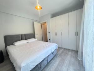 a bedroom with a large bed and white cabinets at Vista Marina Çeşme in Çeşme