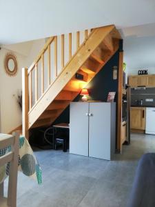 a living room with a staircase and a refrigerator at Gîte 2étoiles le Pouldu, 3 plages à pied in Clohars-Carnoët