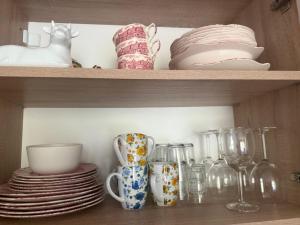 a shelf with plates and cups and dishes on it at Flat in Cascadas 21 in Sunny Beach