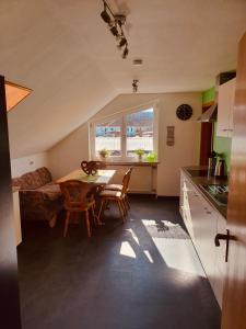 a kitchen and living room with a table and chairs at Ferienwohnung Sulzfeld - Liebevoll eingerichtete Ferienwohnung in Sulzfeld im Grabfeld in Sulzfeld (im Grabfeld) +10 photos