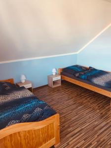 two beds in a room with blue walls and wooden floors at Ferienwohnung Sulzfeld - Liebevoll eingerichtete Ferienwohnung in Sulzfeld im Grabfeld in Sulzfeld (im Grabfeld)