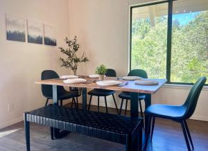 a dining room table with chairs and a table and a window at Brentwood Haus in Lake Arrowhead +19 photos