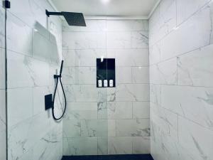 a bathroom with a shower with white tiles at Brentwood Haus in Lake Arrowhead