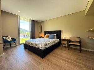 a bedroom with a bed and a table and a chair at Perral Nature - Casa do Carvalho - Gerês in Terras de Bouro +60 photos