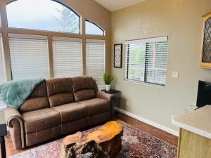 a living room with a brown couch and a log at Rogue River Landing Resort Cabins in Gold Beach