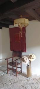 una stanza con una sedia, un cappello e un soffitto di Casa Solariega de Cervantes a San Román