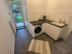 a laundry room with a sink and a washing machine at Pestalozzi Beach & City Apartment in Bremerhaven