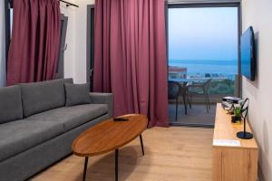 un soggiorno con un divano e un tavolo di Enalis Studios & Apartments a Karfás