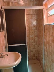 a bathroom with a sink and a shower at Casa da Tia Lá próximo ao Santuário Nacional preço único pela casa cabem até seis pessoas in Aparecida