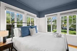 a bedroom with a bed with blue walls and windows at The Adaline Room #5 - Upscale Hyde Park Apartment, 1st Floor, Steps to Bayshore in Tampa +24 photos