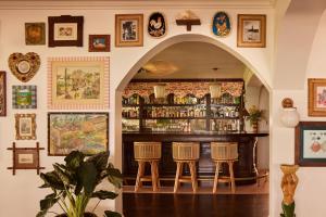 a bar with stools in a room with pictures on the wall at Coral Sands Villa w/ Private Pool – Steps to the Beach & Full Resort Amenities in Harbour Island