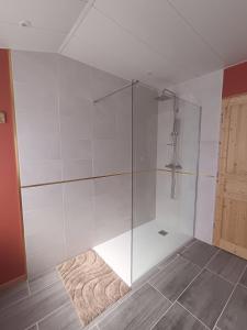a glass shower in a bathroom with a rug at Le rouge baiser Love room in Ault +7 photos